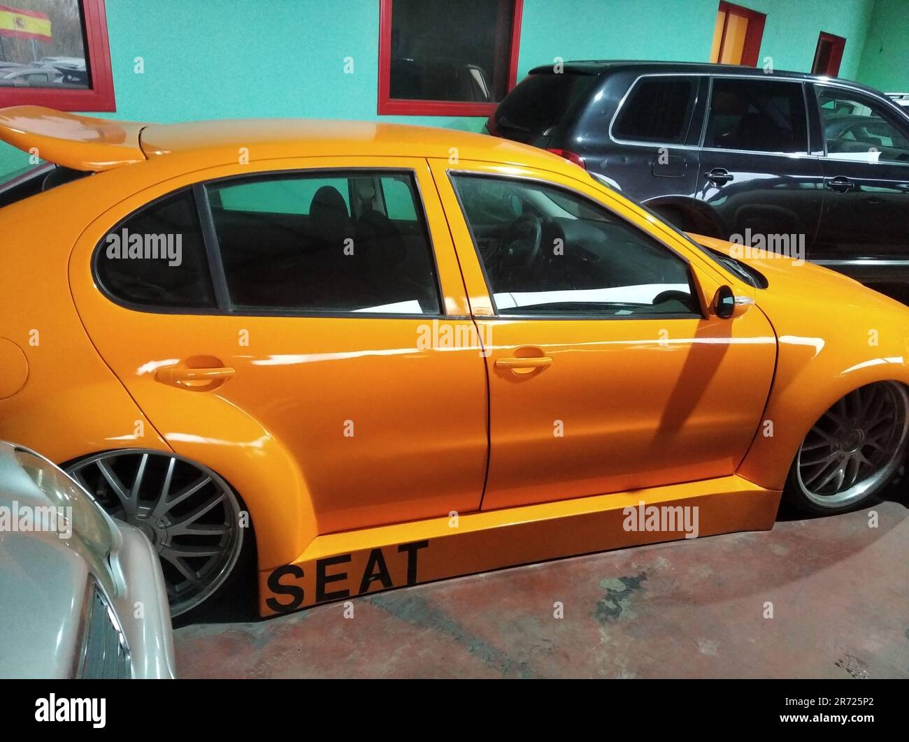 Une voiture de course orange garée dans un parking avec d'autres voitures  Photo Stock - Alamy