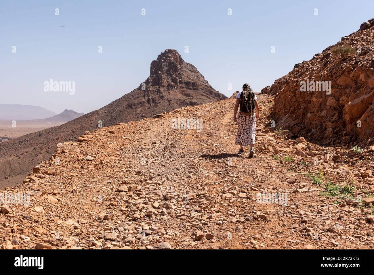 Randonnée sur le mont Zagora sur une route de gravier, le mont Adafane en arrière-plan, la vallée du Draa au Maroc Banque D'Images