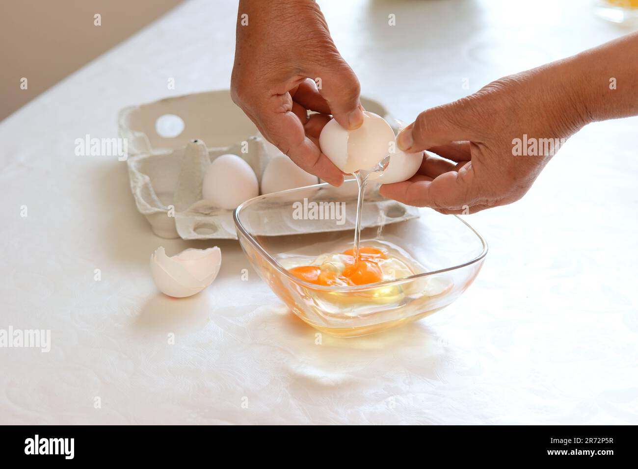Une femme fend des œufs dans Un bol Banque D'Images