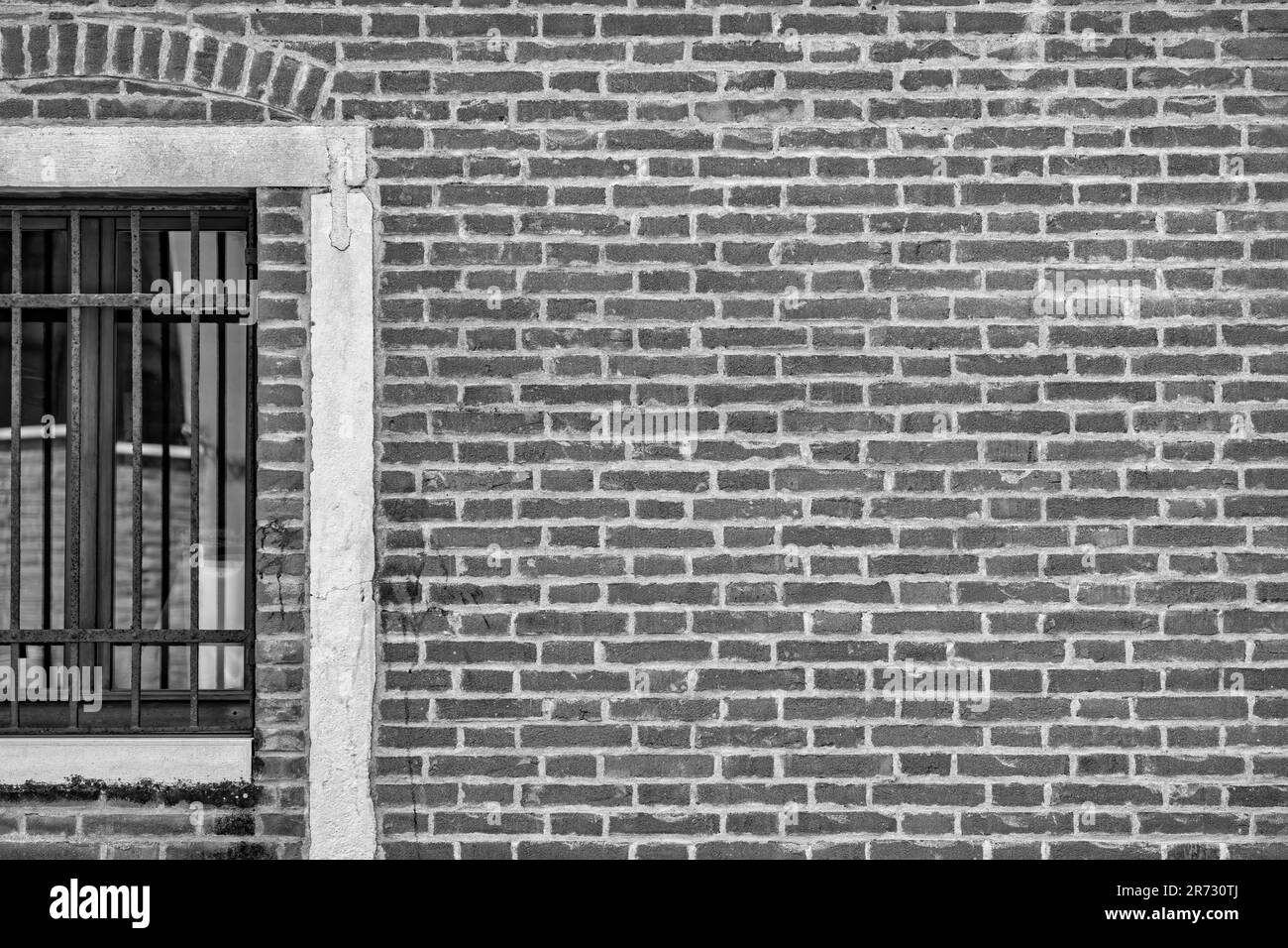 Gros plan avec une ancienne fenêtre vénitienne à l'architecture médiévale. Photographie en noir et blanc. Banque D'Images