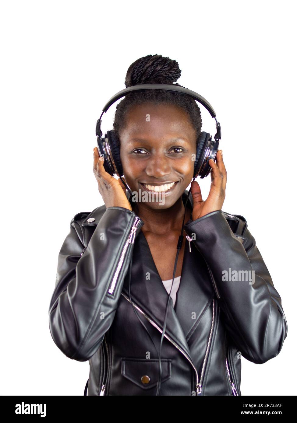 Jeune femme portant une veste en cuir écoutant de la musique avec des écouteurs sur un fond blanc Banque D'Images