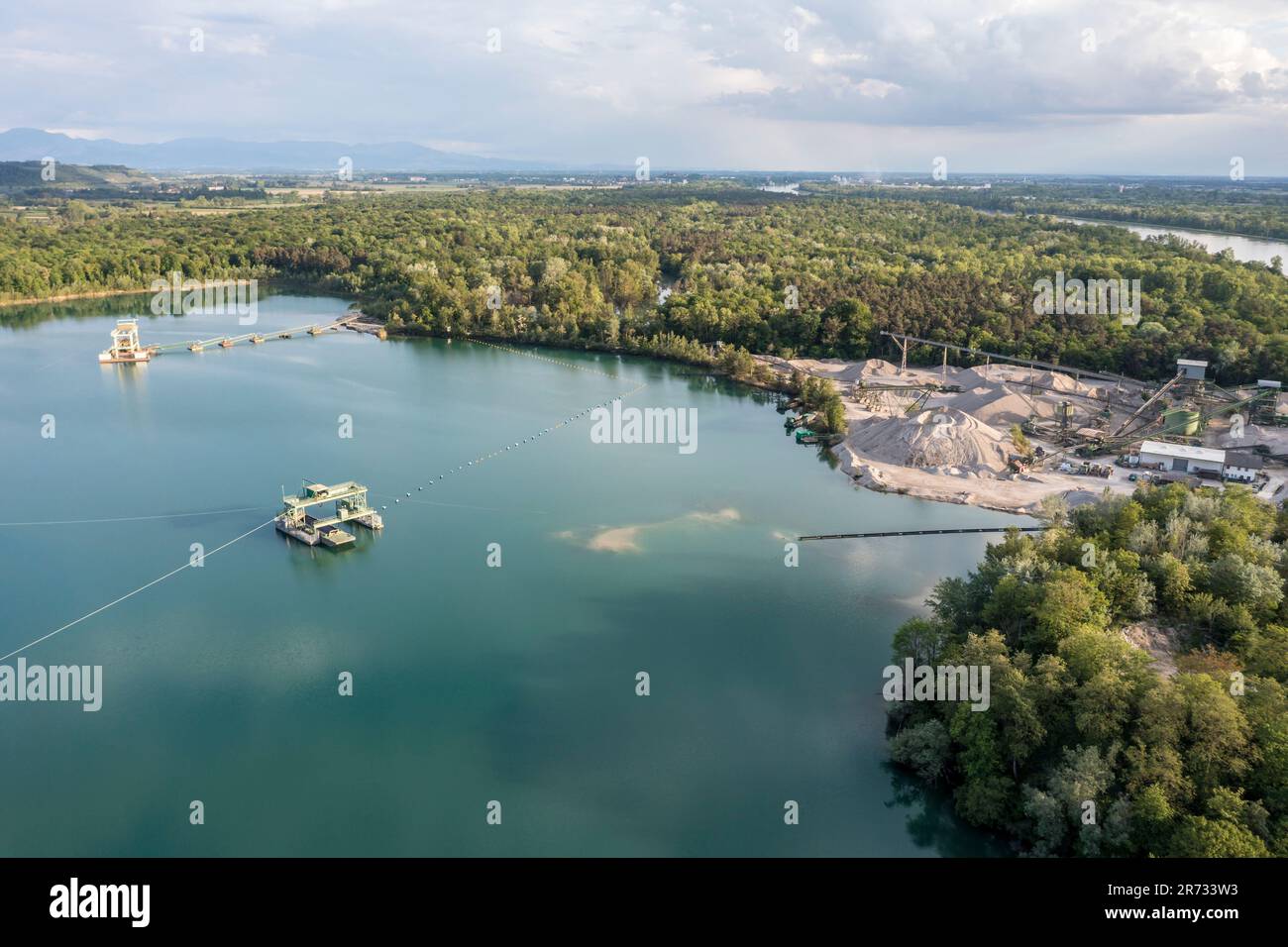 Vue aérienne de l'étang de carrière turquoise d'une fosse de gravier, excavation et aire de chargement au Rhin, Burkheim, vallée du Rhin, Allemagne Banque D'Images