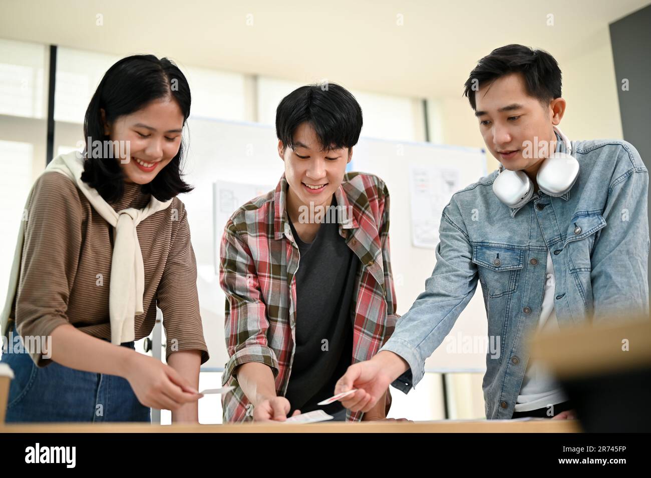 Une équipe de graphistes asiatiques professionnels ou de développeurs techniques réfléchis et discute de leur nouveau projet dans la salle de réunion ensemble. tech Banque D'Images