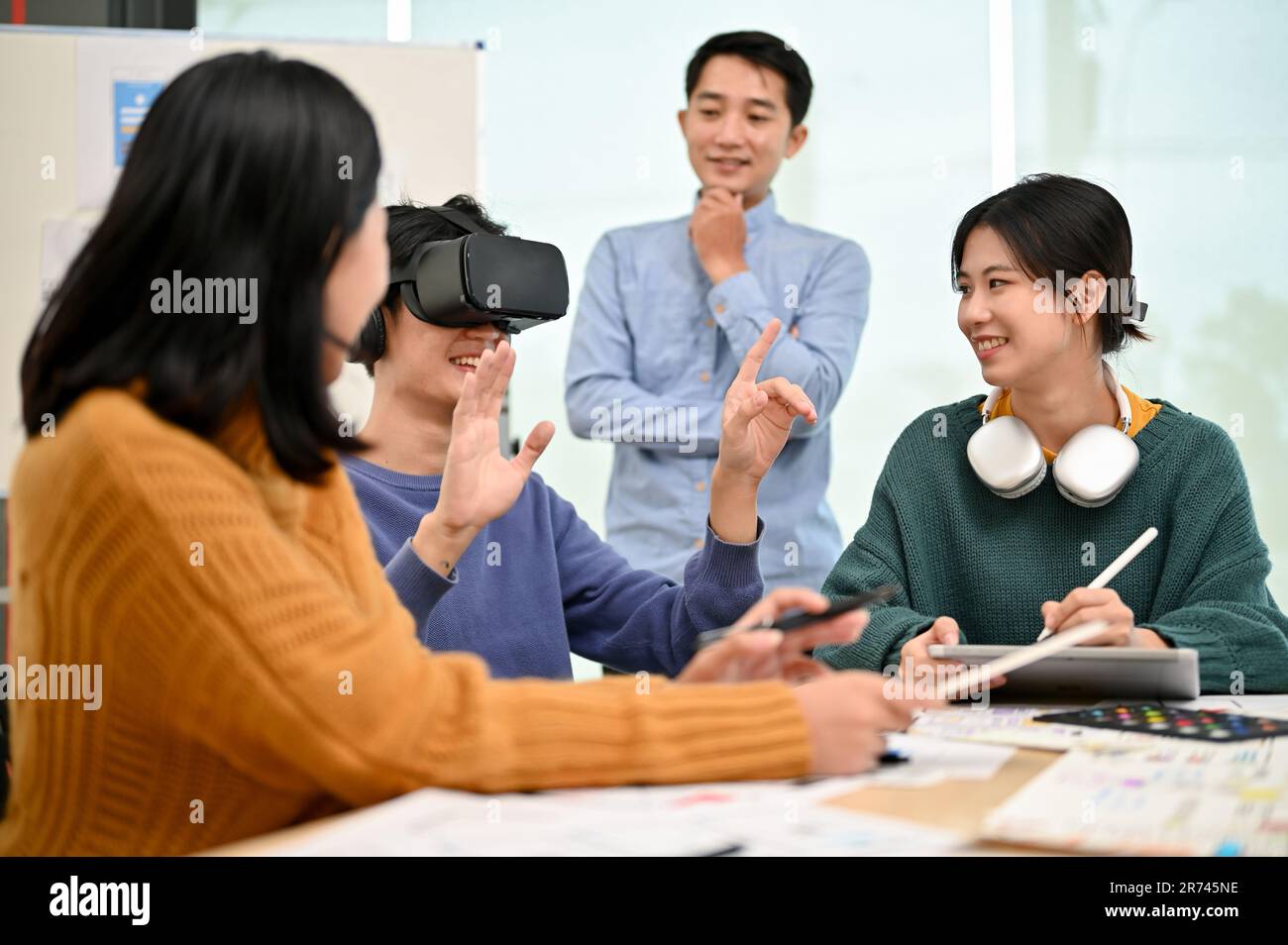 Un jeune homme asiatique enthousiaste a testé un nouveau casque de réalité virtuelle avec son équipe dans le bureau de création. technologie, innovation, démarrage technologique Banque D'Images