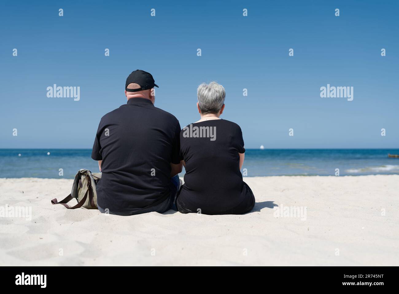 Couple assis sur la plage de la mer Baltique près de Kühlungsborn appréciant la journée d'été en vacances Banque D'Images