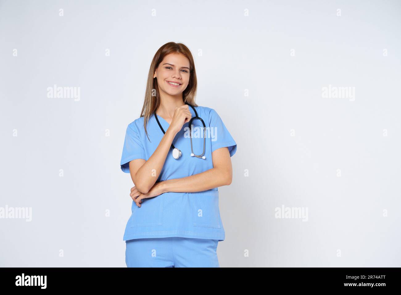 Portrait de femme souriante médecin en manteau bleu debout isolé sur fond blanc. Banque D'Images