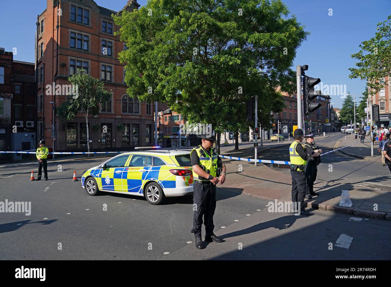 Des policiers au carrefour Maid Marian Way de la rue Upper Parliament à Nottingham, comme la police a mis en place plusieurs fermetures de routes à Nottingham, car les policiers sont confrontés à un incident grave en cours. Le réseau de tramway de Nottingham Express Transit (NET) a déclaré avoir suspendu tous les services en raison d'incidents de la police dans la ville et la banlieue. Date de la photo: Mardi 13 juin 2023. Banque D'Images