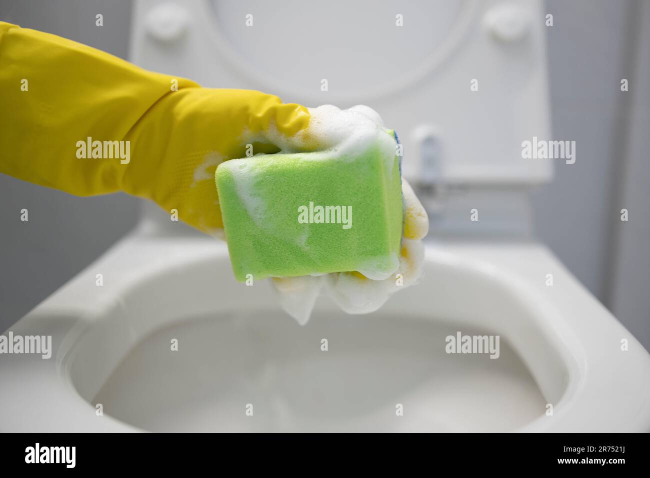 Nettoyer les toilettes, nettoyer le pourtour des toilettes avec une éponge de nettoyage, détail, Banque D'Images