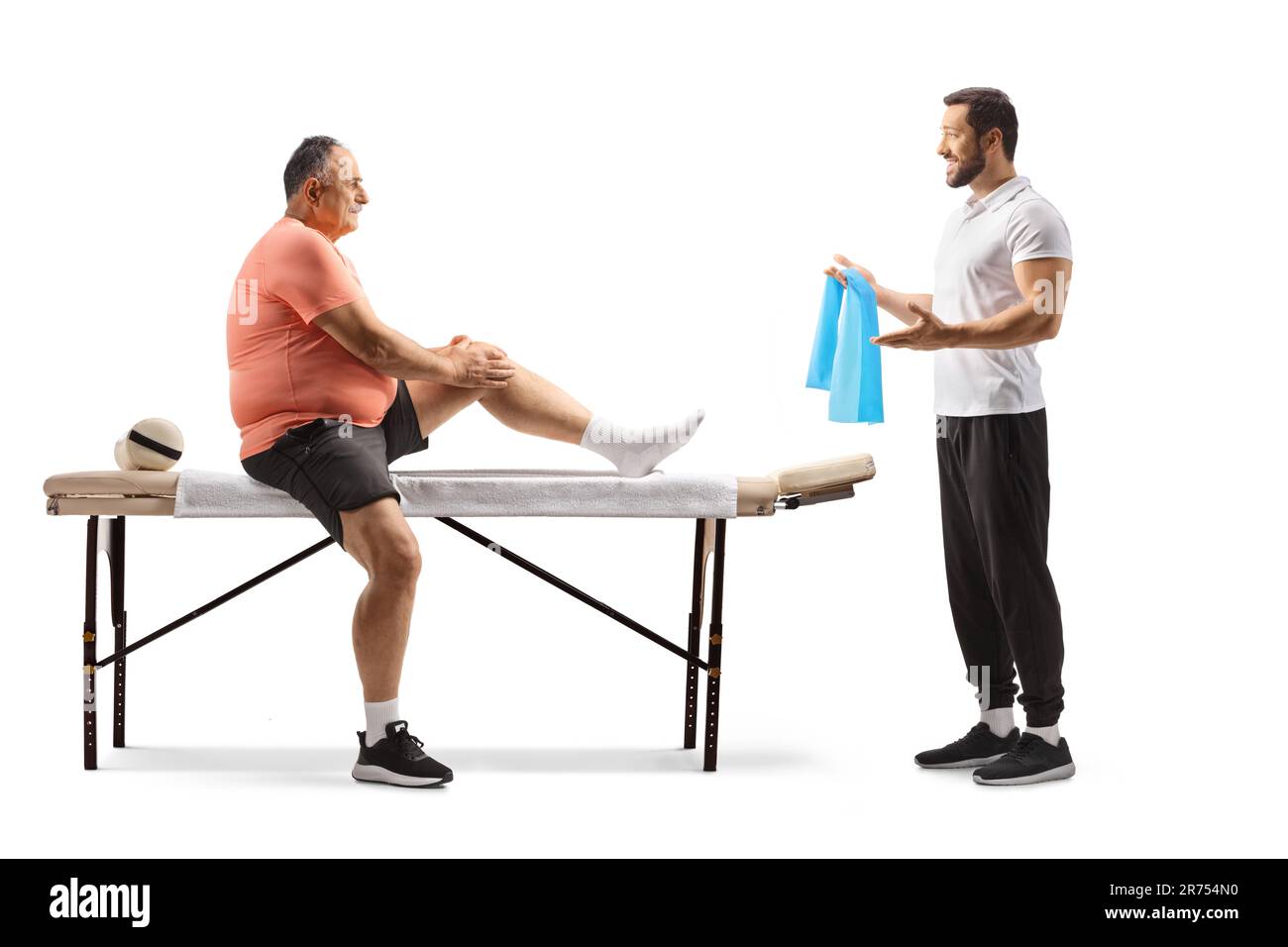 Thérapeute physique montrant l'exercice à un homme mature avec un genou blessé isolé sur fond blanc Banque D'Images