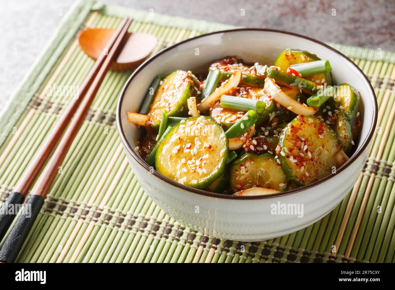 Salade de concombre coréen épicé Oi Muchim faite avec de l'ail, de l'oignon, du sésame et des poivrons chauds sur la table. Horizontale Banque D'Images