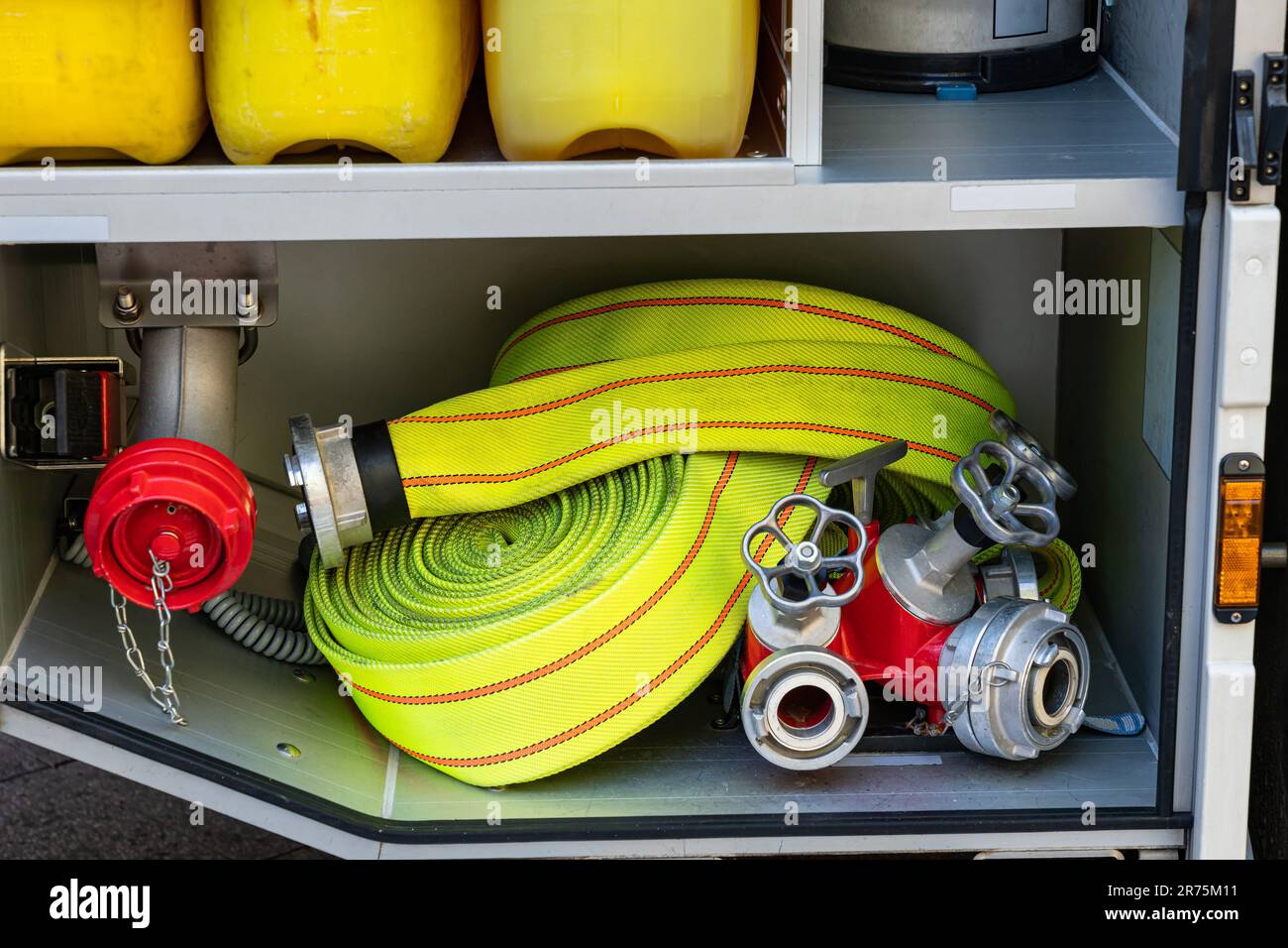 Tuyau d'incendie jaune enroulé et un séparateur d'eau avec vannes dans une  piste d'incendie. Gros plan Photo Stock - Alamy