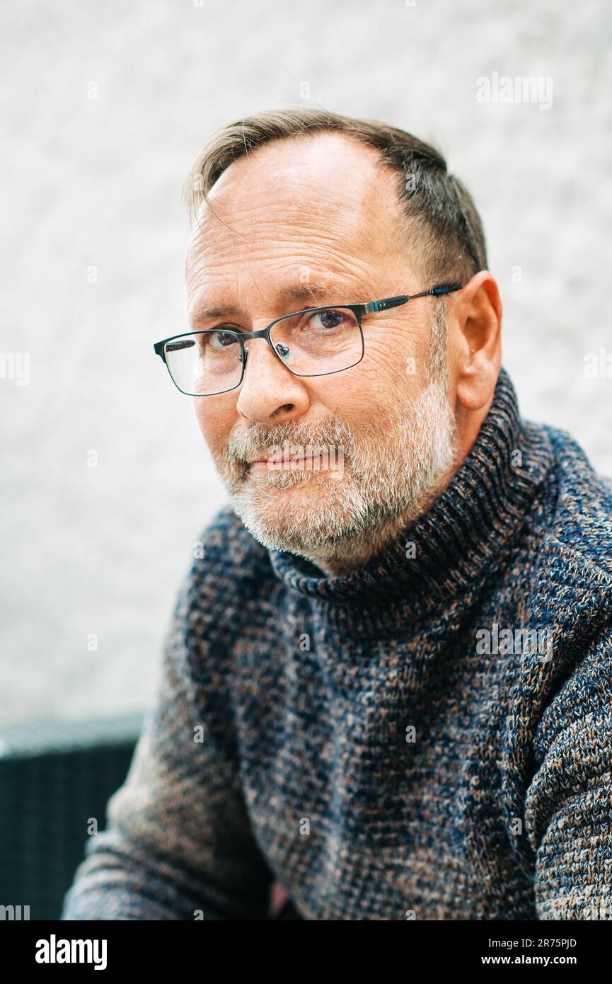 Portrait extérieur d'un homme de 50 ans portant un pull-over et des lunettes marron Banque D'Images