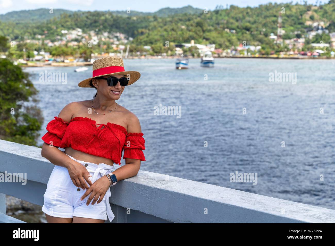 Amérique du Nord, Caraïbes, Grande Antilles, Île d'Hispaniola, République dominicaine, Province de SAMA, péninsule de Sama, Santa rbara de Sama, jolie Latina penchée sur la main courante du pont dans la baie de Sama Banque D'Images