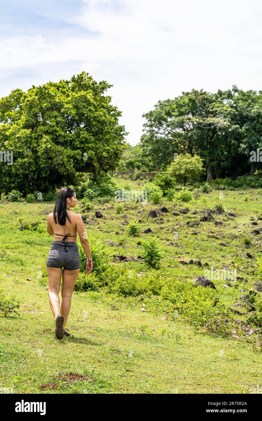 Amérique du Nord, Caraïbes, Grande Antilles, Île d'Hispaniola, République dominicaine, Province de SAMA, péninsule de Sama, femme attrayante se promenant à travers un pré Banque D'Images