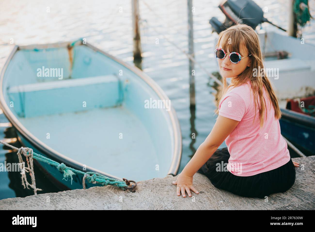 Petite fille qui se repose dans un petit port pendant les vacances d'été Banque D'Images