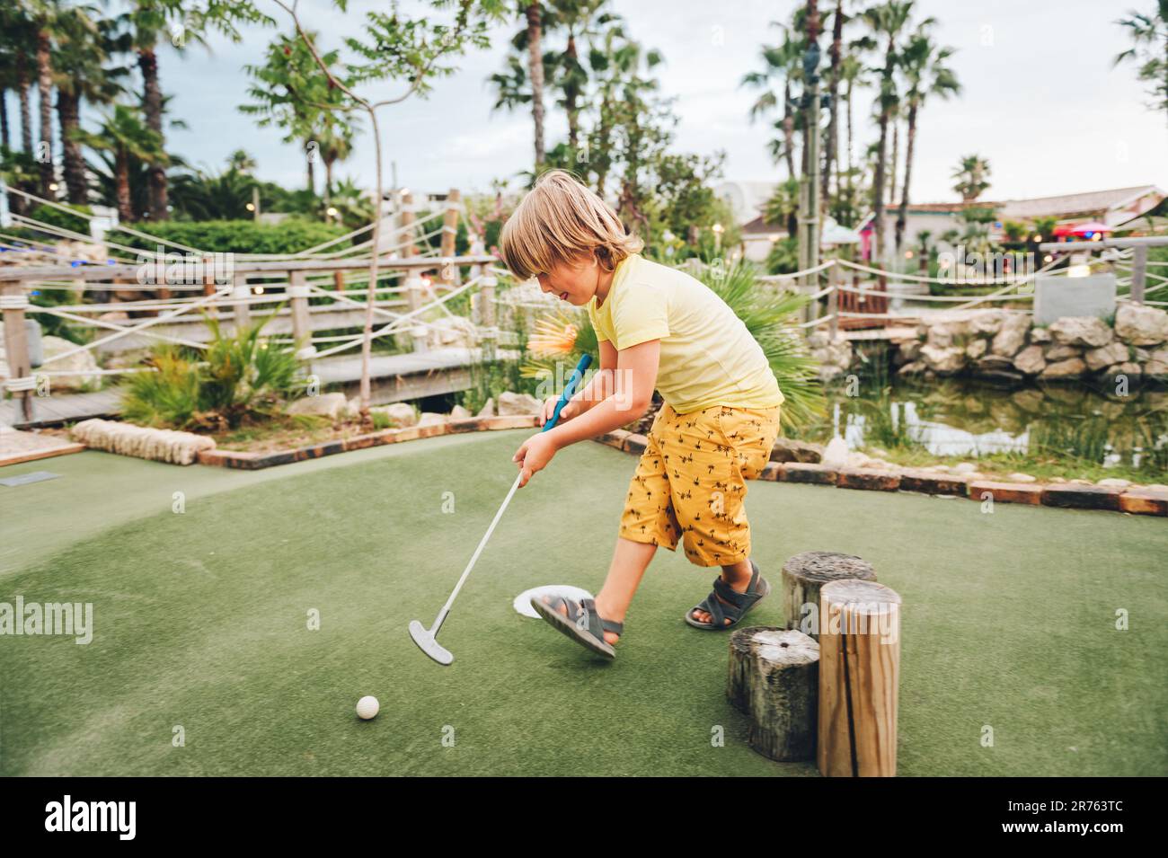 Drôle enfant garçon jouant au mini-golf, enfant appréciant les vacances d'été Banque D'Images