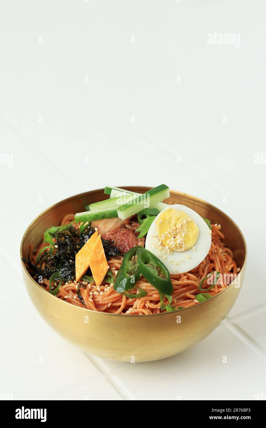 Bibim Guksu Korean Spicy nouilles froides avec divers garnitures. Isolé sur fond blanc Banque D'Images