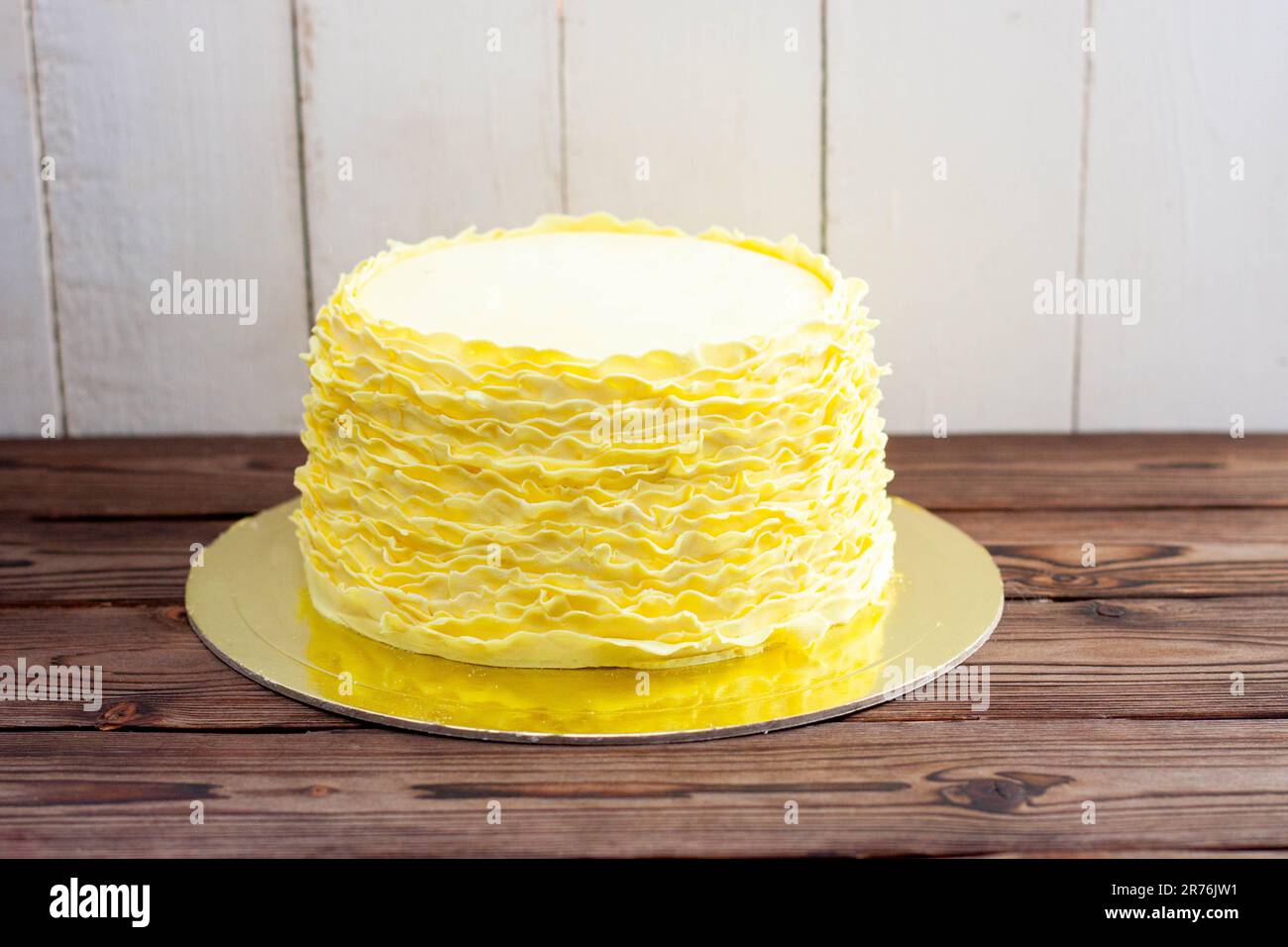 Gâteau jaune aux volants fondants sur fond de bois rustique Banque D'Images
