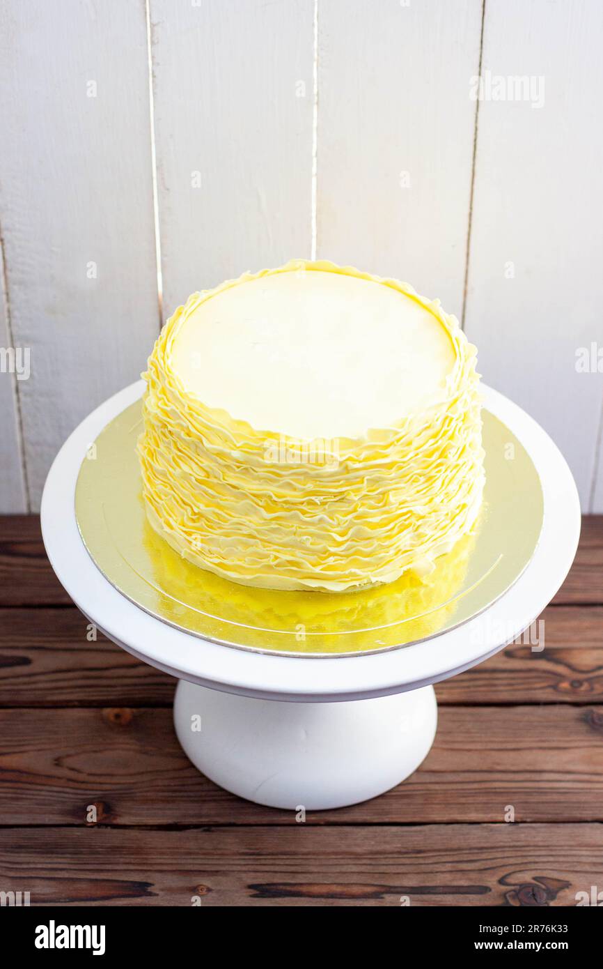 Gâteau jaune aux volants fondants sur fond de bois rustique Banque D'Images