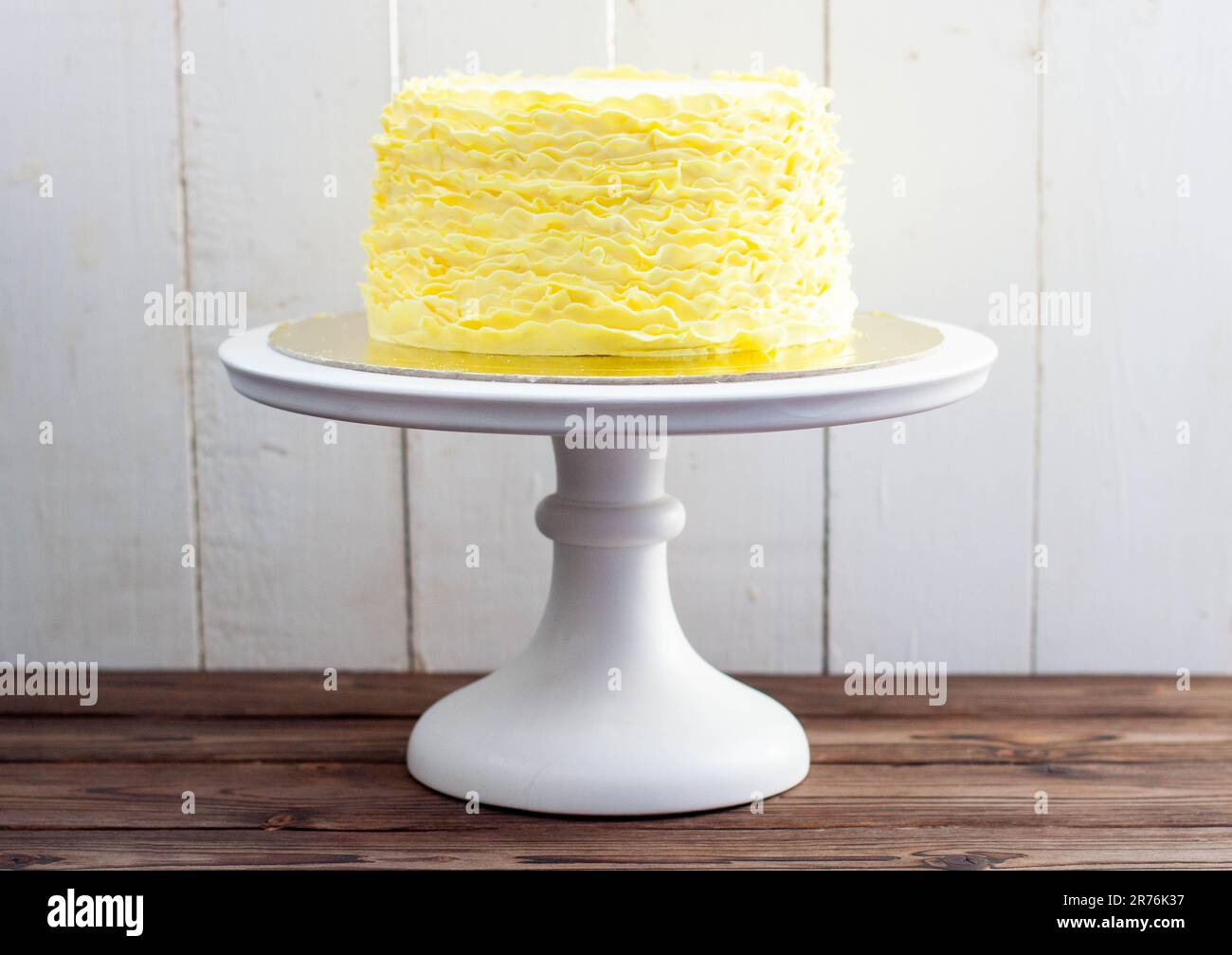 Gâteau jaune aux volants fondants sur fond de bois rustique Banque D'Images