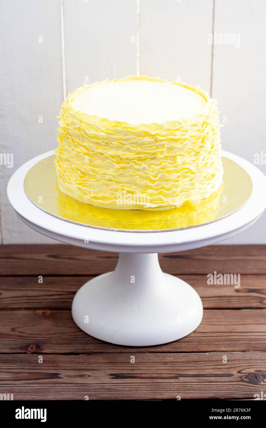 Gâteau jaune aux volants fondants sur fond de bois rustique Banque D'Images