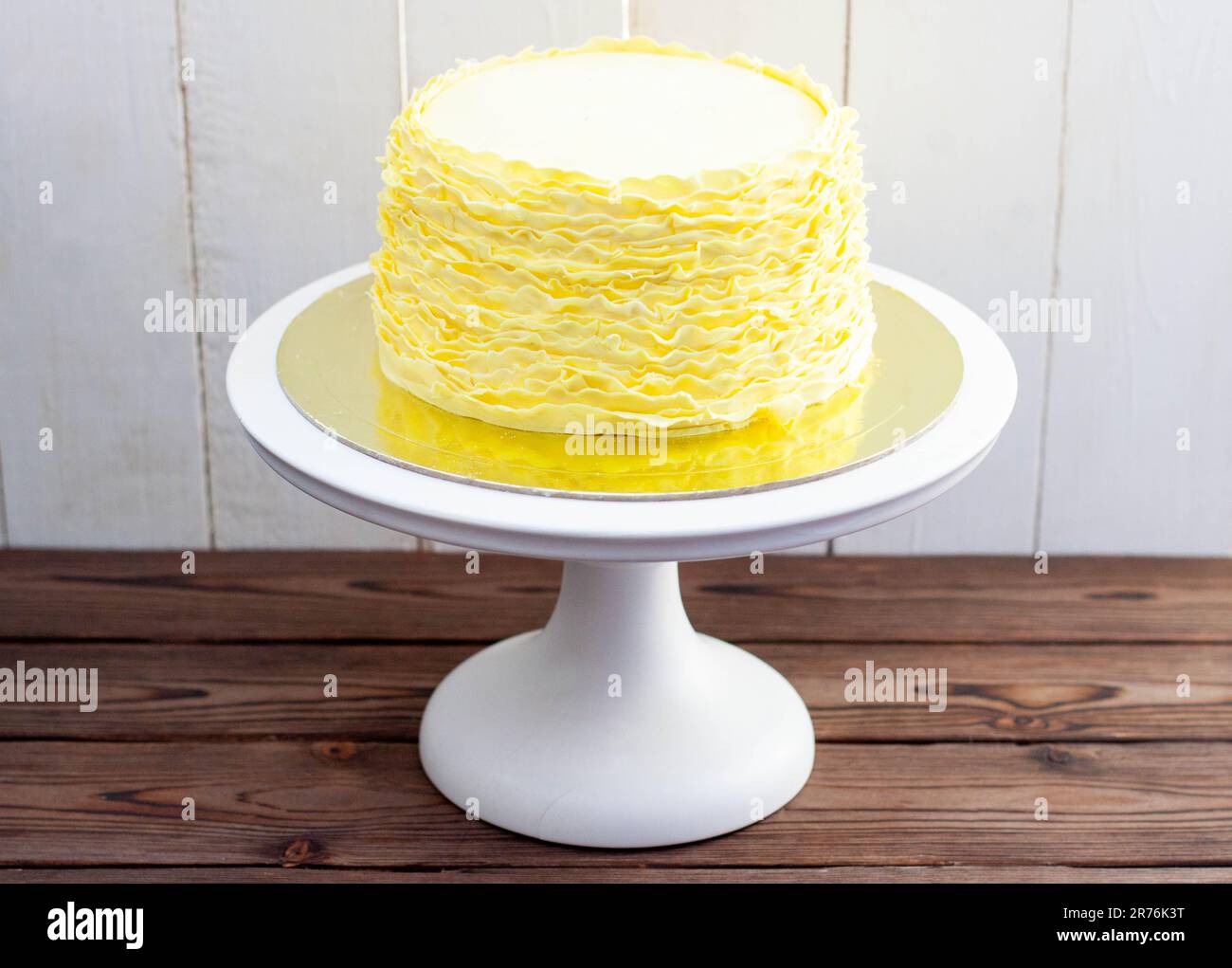 Gâteau jaune aux volants fondants sur fond de bois rustique Banque D'Images