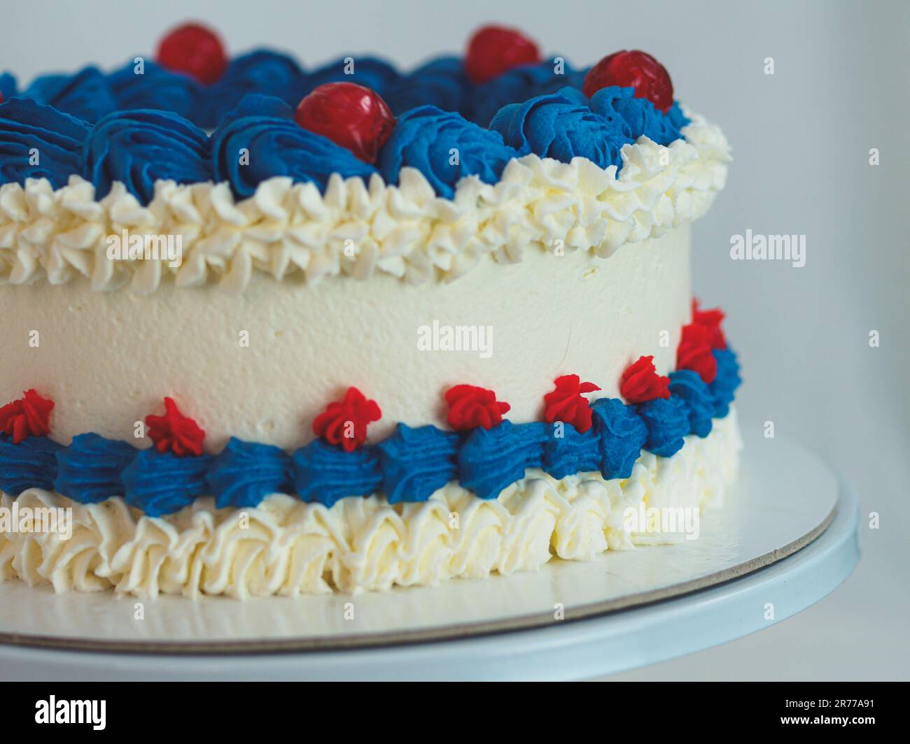 gâteau givré blanc bleu rouge isolé sur fond blanc de studio. Couleurs du drapeau américain. Célébration. Banque D'Images