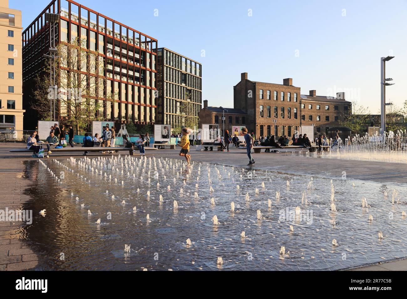 Profitez du soleil sur les fontaines de Granary Square, à Kings Cross, au nord de Londres, au Royaume-Uni Banque D'Images