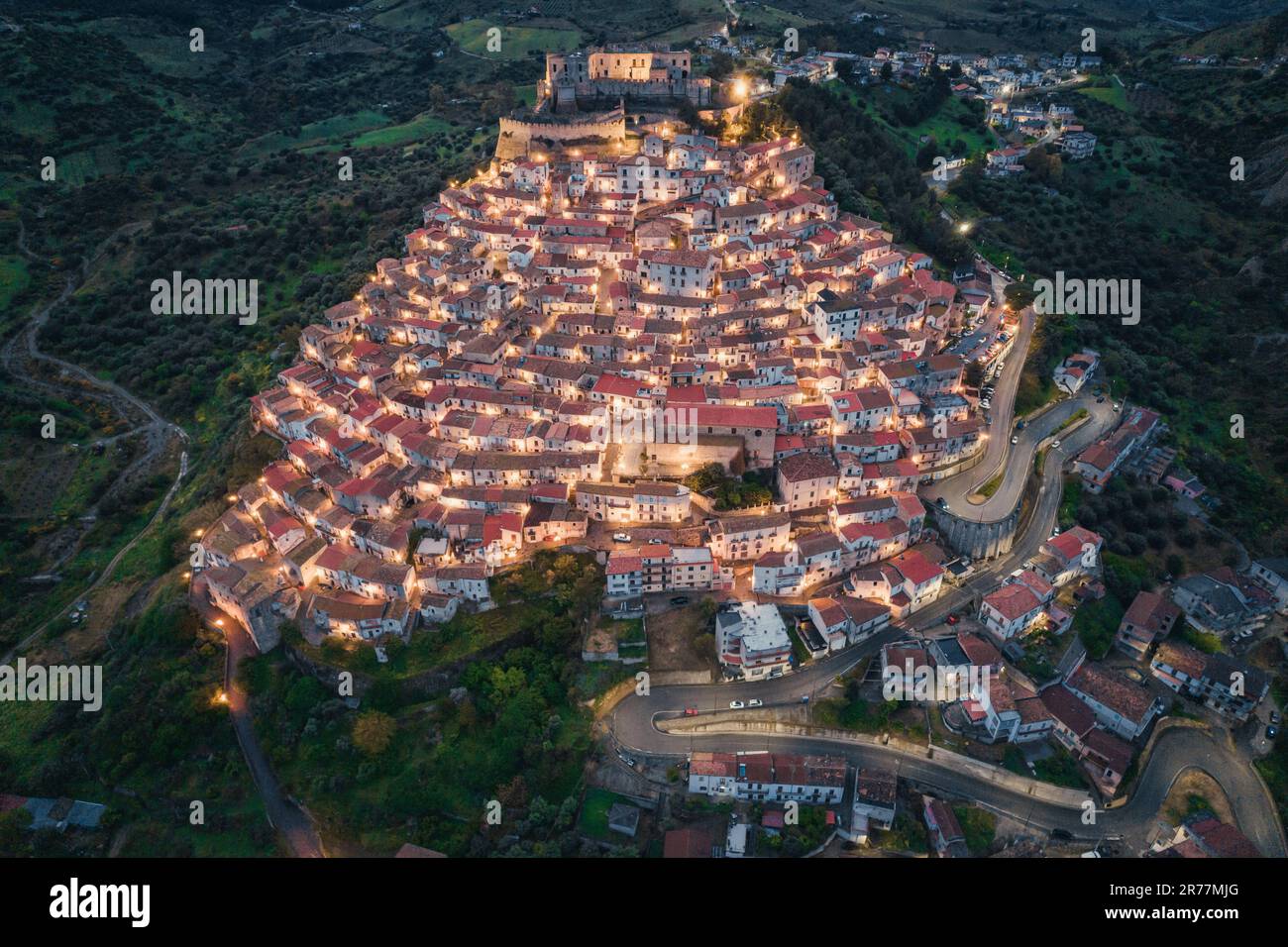 Vue aérienne de la ville italienne au sommet d'une colline, Rocca Imperiale au crépuscule dans la région de Calabre Banque D'Images