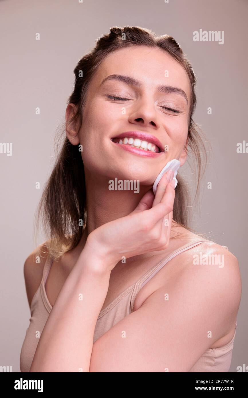 Femme, visage ou tampon en coton pour soins de la peau, produit de  nettoyage de dermatologie ou traitement d'acné de visage. Modèle portrait,  sourire ou beauté heureuse avec wip Photo Stock 