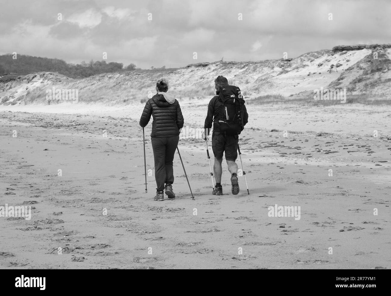 Randonneurs sur une plage balayée par le vent, au sud de Granville, en Normandie, en France, en Europe Banque D'Images