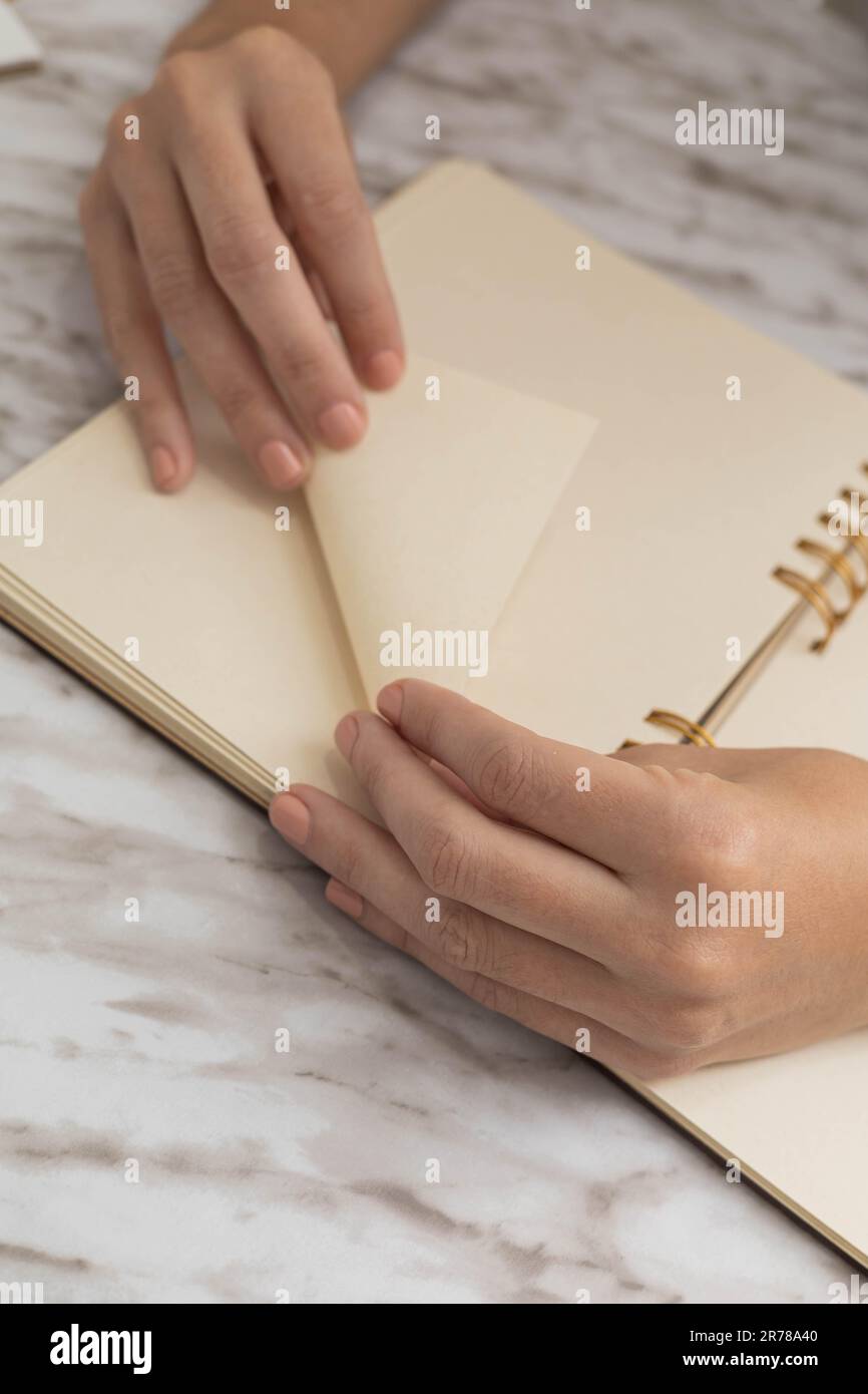 pliage de la feuille de papier à partir d'un carnet, exécution de l'origami, activité créative et artistique, détails de la papeterie objets dans le studio Banque D'Images