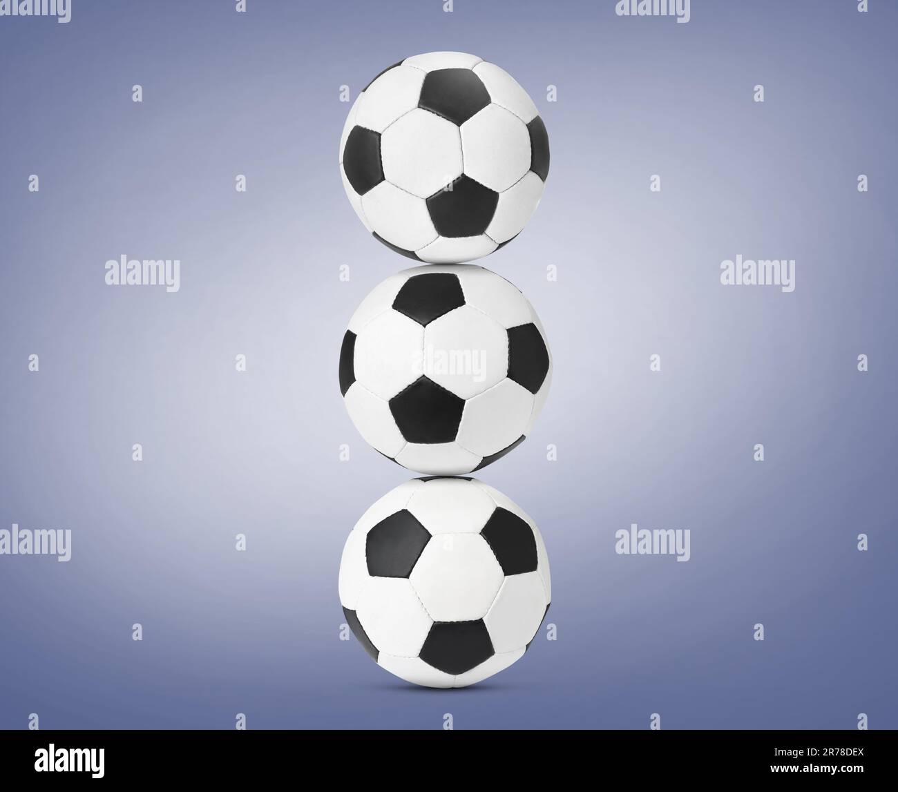 Pile de ballons de football sur fond bleu pâle Banque D'Images