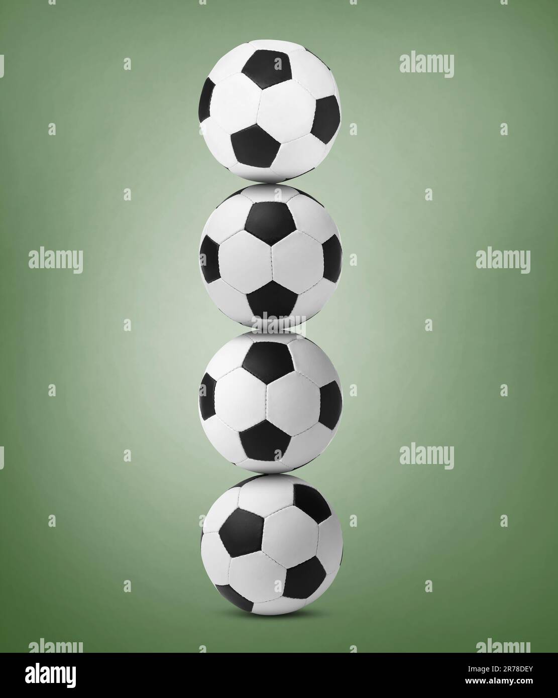Pile de ballons de football sur fond vert pâle Banque D'Images