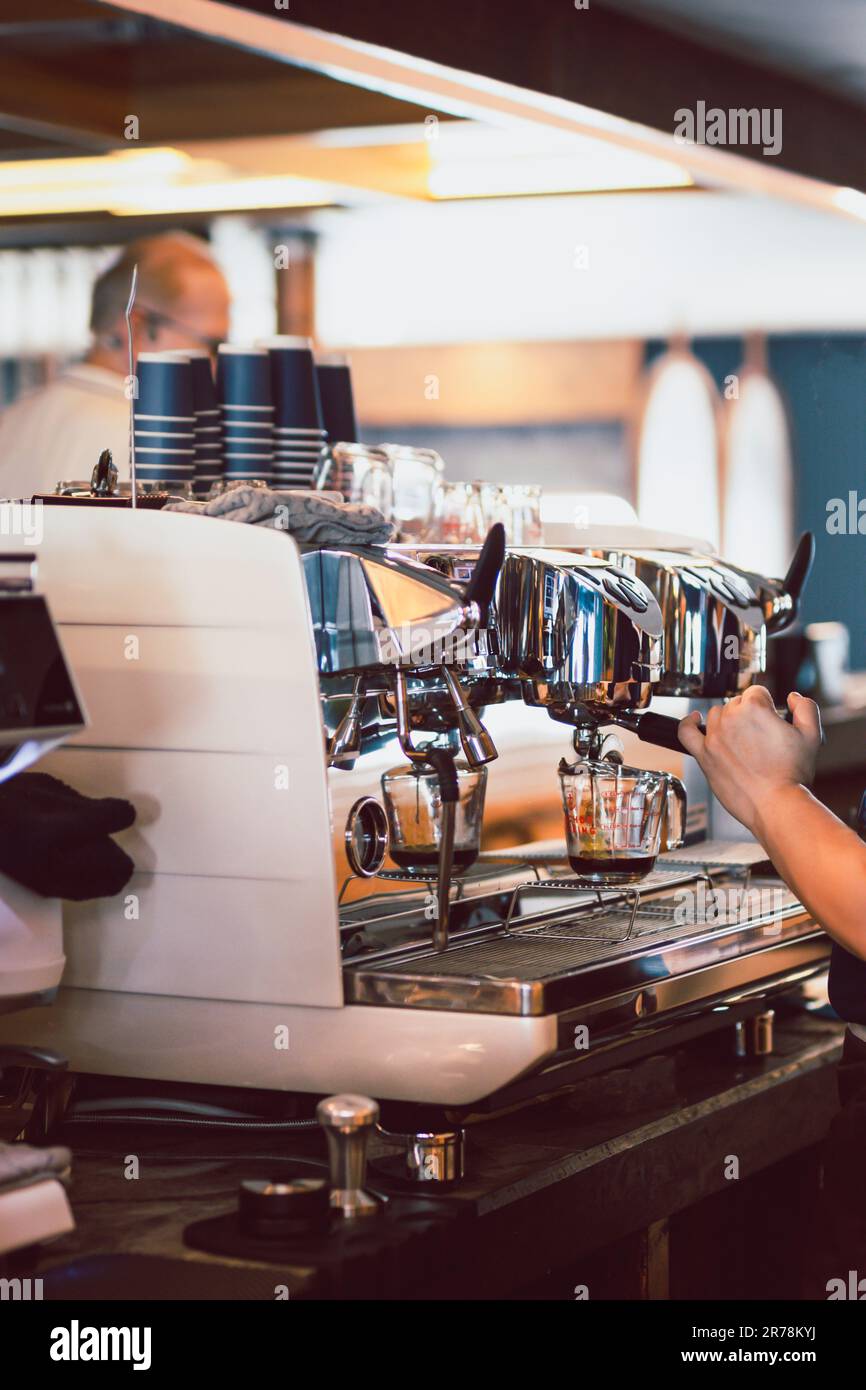 Main du barista masculin qui prépare du café pour les clients. Banque D'Images