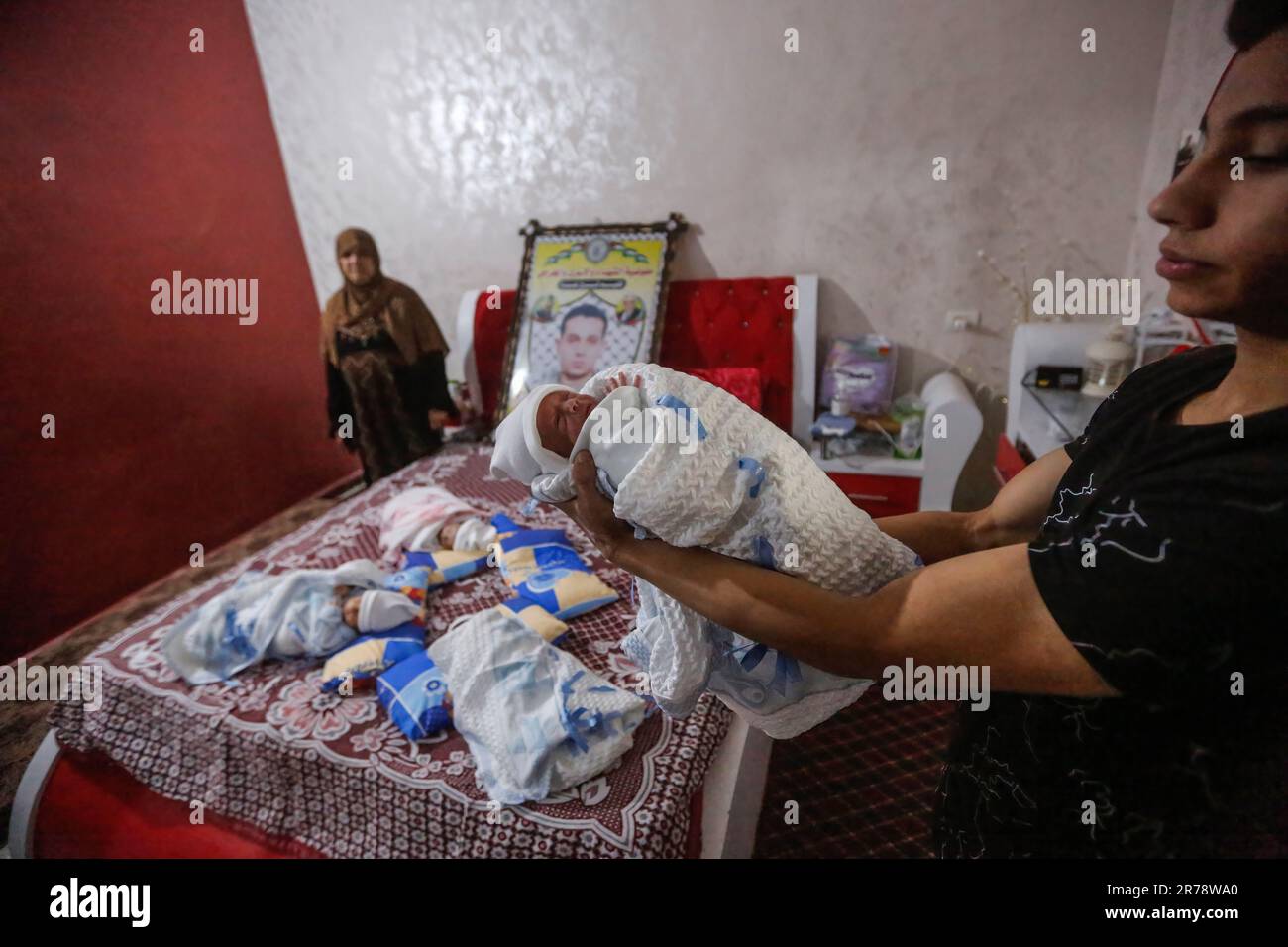 Ali Shamali le grand frère des quadriplets en porte un, dans leur maison familiale dans le quartier Al Shejaiya. La femme de la prisonnière palestinienne Ahmad al-Simali, Rasmeia, âgée de 38 ans, arrive avec ses bébés à Gaza après qu'elle ait donné naissance à des quadriplets de sperme en contrebande provenant de la prison israélienne à l'hôpital de la Société de charité islamique de Makassed à Jérusalem. Les bébés, trois hommes et une femme, ont été conçus avec le sperme de leur père, Ahmed Shamali, qui est emprisonné en Israël depuis 2008. Selon le Centre palestinien d'études sur les prisonniers, plus de 100 enfants sont nés en recen Banque D'Images