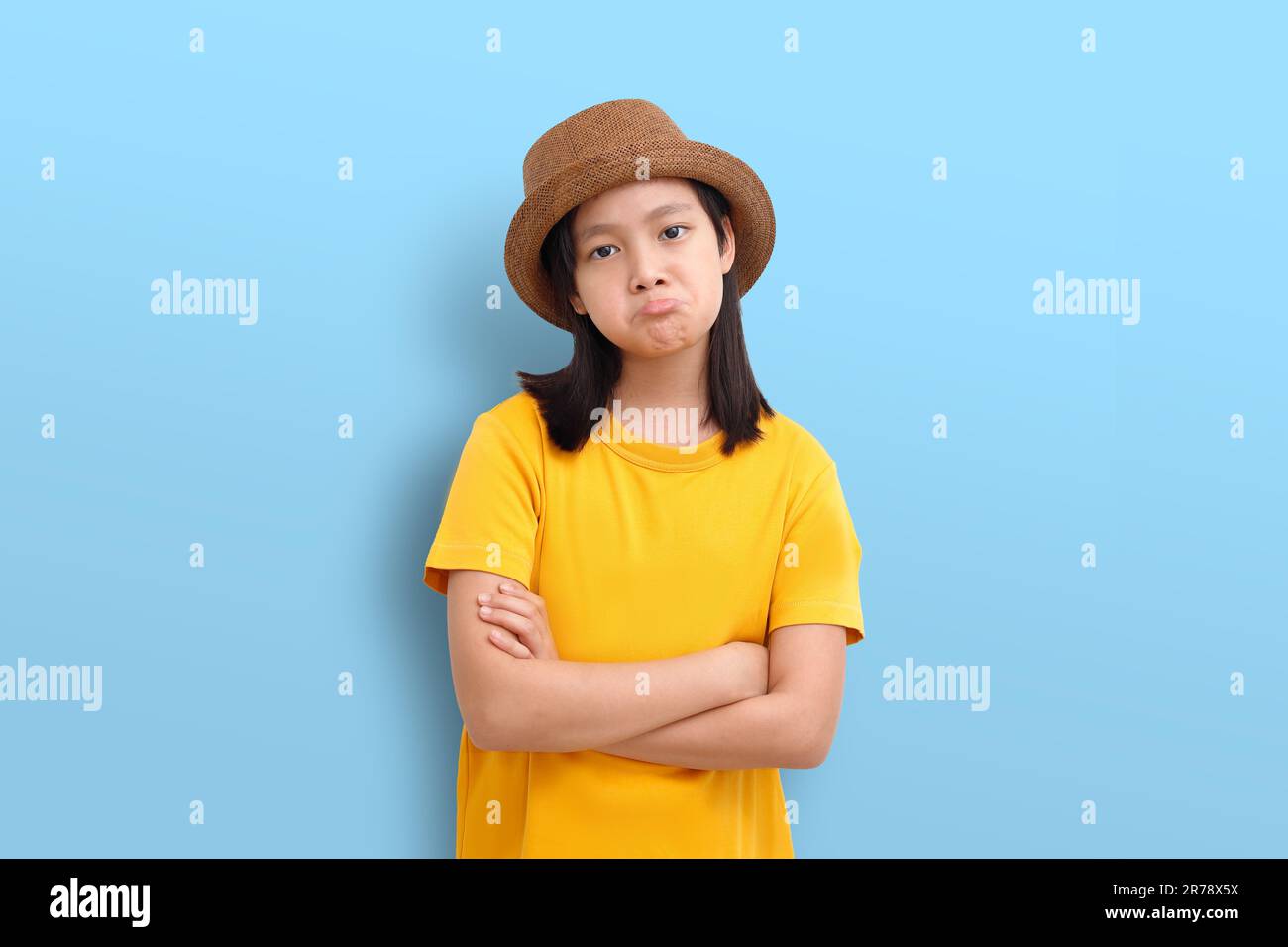 Le visage sensuel d'une fille asiatique affiche des émotions. Photo isolée sur fond bleu. Banque D'Images