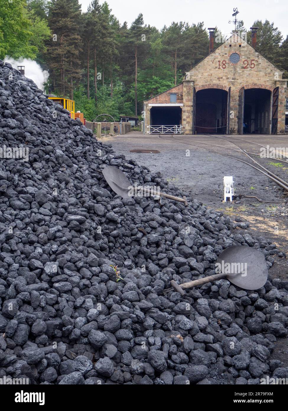 Pile de charbon à la gare de train à vapeur avec des pelles abandonnées qui attendent d'être utilisées au musée Beamish, comté de Durham, Royaume-Uni Banque D'Images