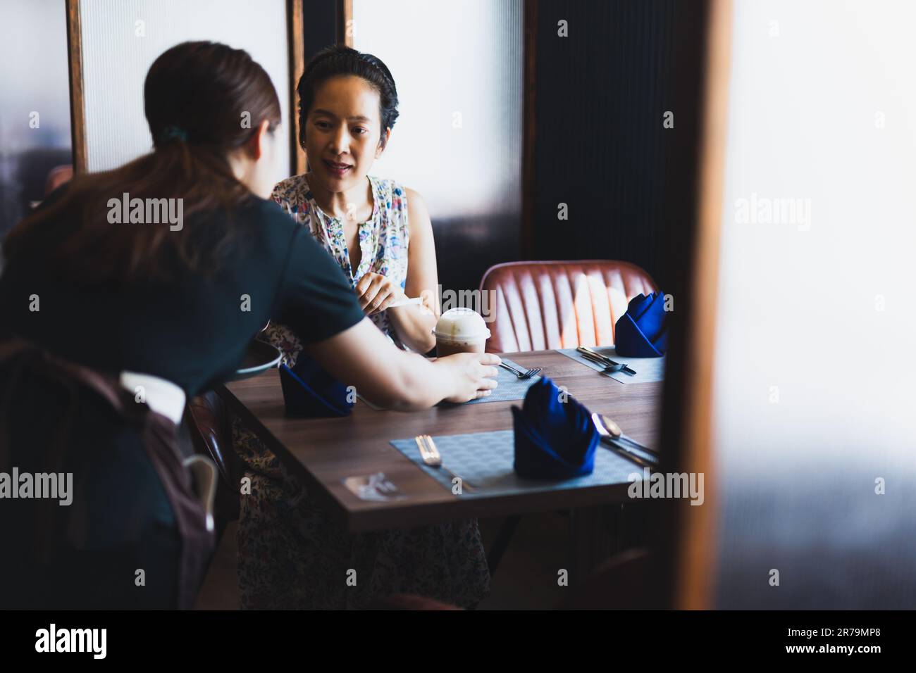 Serveuse servant du café glacé à une cliente dans un café. Banque D'Images