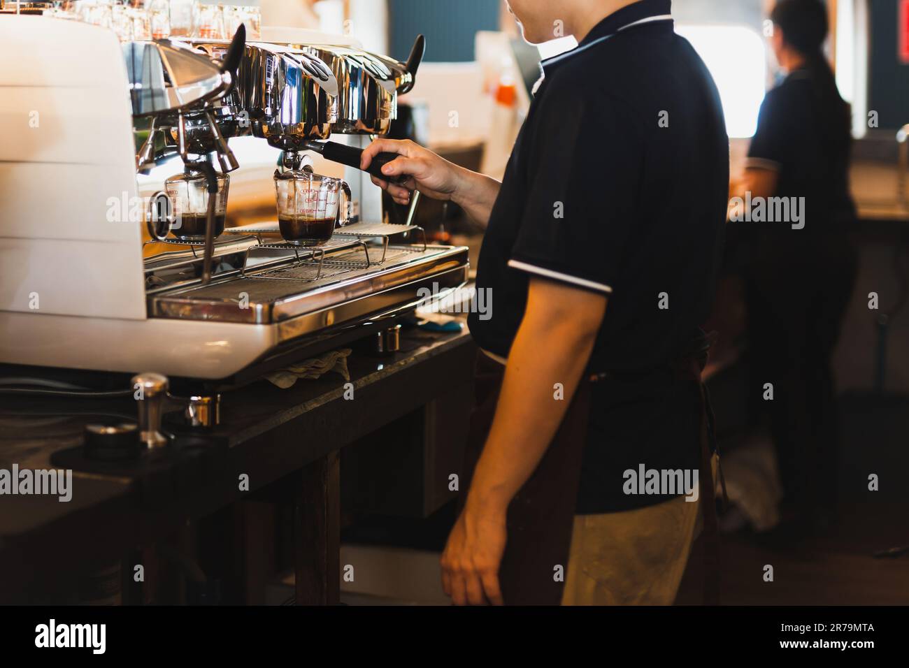 Main du barista masculin qui prépare du café pour les clients. Banque D'Images
