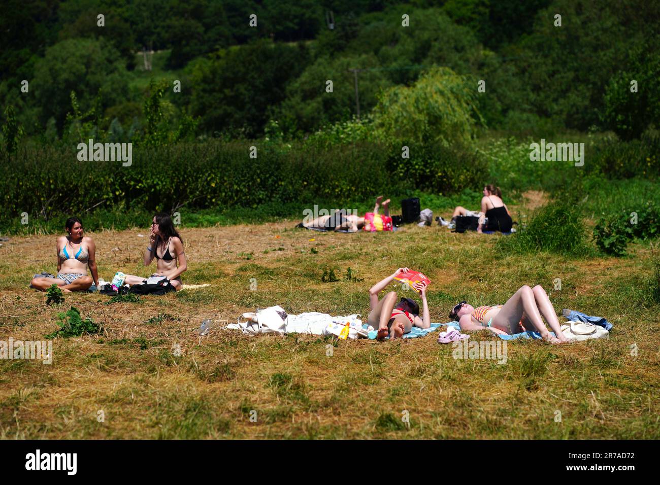 Les personnes qui bronchent à Warleigh Weir près de Bath. Le Bureau met a publié des directives indiquant que la plupart des Britanniques respecteront les critères des vagues de chaleur cette semaine, et une alerte orange pour les températures chaudes a été émise par l'Agence britannique de sécurité sanitaire (UKHSA). Date de la photo: Mercredi 14 juin 2023. Banque D'Images