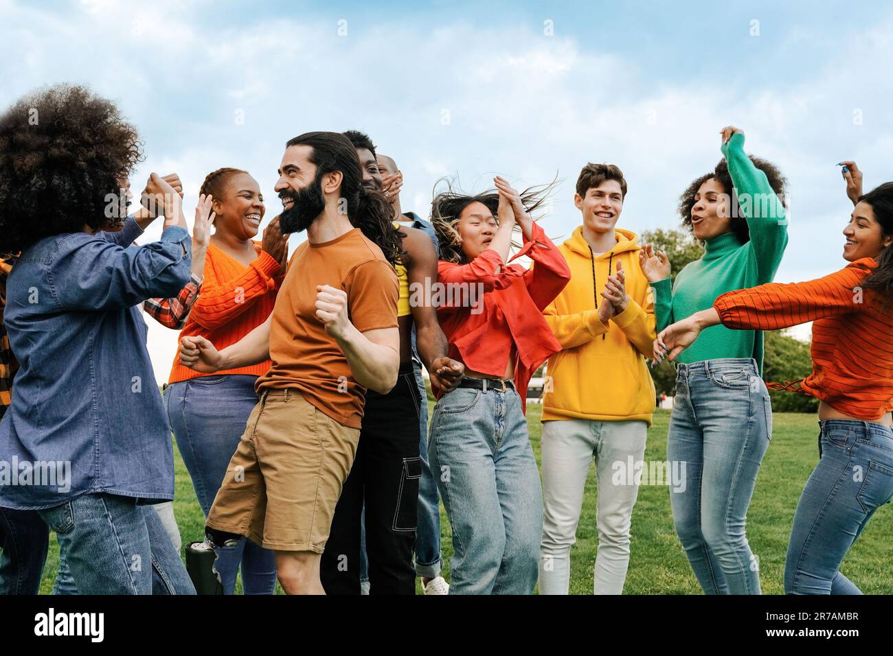 Groupe heureux d'amis dansant au festival de musique fête en plein air - diverses personnes célébrant ensemble - Focus sur le visage de l'homme avec la jambe prothétique Banque D'Images