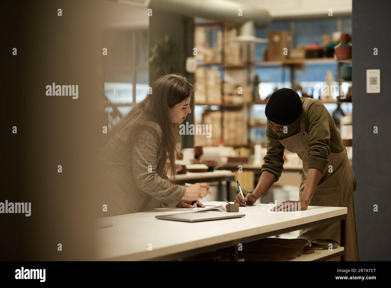 Directeur de studio céramique travaillant avec un collègue à une table Banque D'Images