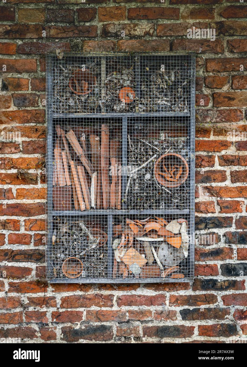 Un hôtel de punaises artificiel ou un abri attaché à un mur rustique de briques rouges Banque D'Images