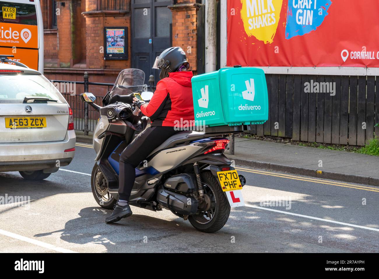 Pilote de livraison Deliveroo sur la moto Honda Forza, Silver Street, Lincoln City, Lincolnshire, Angleterre, ROYAUME-UNI Banque D'Images