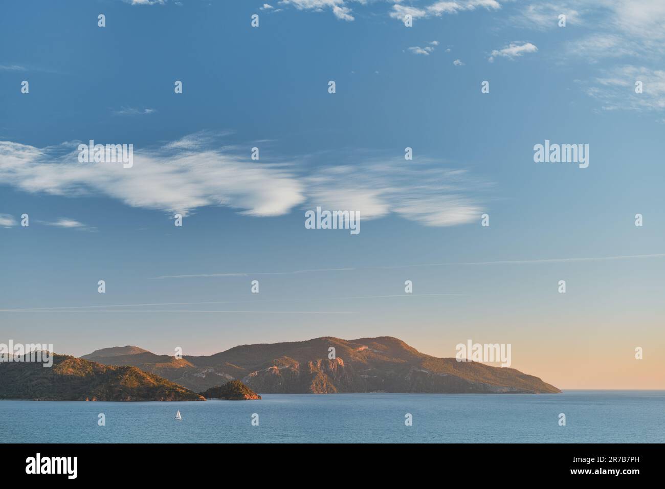 Magnifique coucher de soleil sur la mer Égée avec des îles, des montagnes et un voilier. Paysage marin, voyage et vacances dans la nature, idée pour un fond ou advertisi Banque D'Images