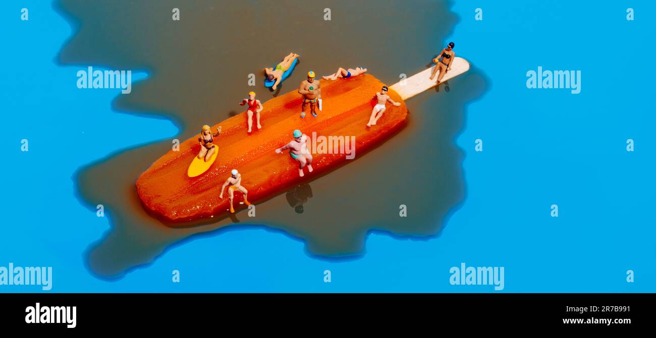 gros plan de quelques personnes miniatures en maillot de bain sur un pop-sicle orange en fusion, sur fond bleu, dans un format panoramique à utiliser comme bannière web Banque D'Images