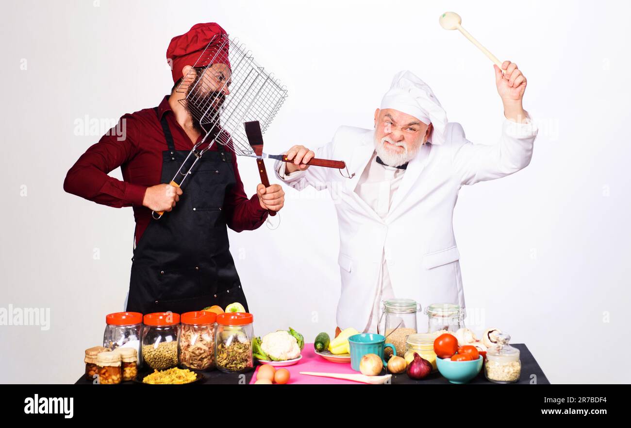 Cuisine professionnelle. Les chefs en uniforme participent au spectacle culinaire. Règles de la cuisine. Défi de cuisine. Bataille culinaire. Deux cuisiniers ou boulanger en lutte avec Banque D'Images