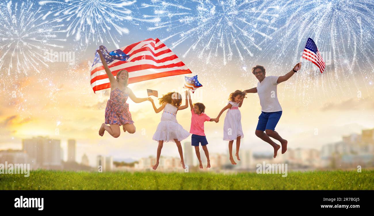 Famille américaine célébrant le jour de l'indépendance. Pique-nique et feux d'artifice le 4 juillet en Amérique. Drapeau des États-Unis. Les parents et les enfants célèbrent les vacances aux États-Unis. Banque D'Images