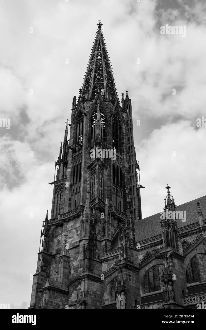 Cette photographie en noir et blanc représente une grande cathédrale avec une tour d'horloge qui se profile en arrière-plan Banque D'Images